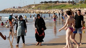 Islam vs secularism reflected in dress on the beach.
