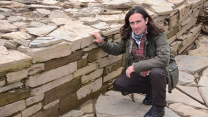 Neil Oliver with the foundations of A stone age temple on Orkney
