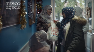 Muslim women clutch a Tesco shopping bag. But Muslims don't believe the truth of Christmas and Tesco don't even have a halal turkey for them.