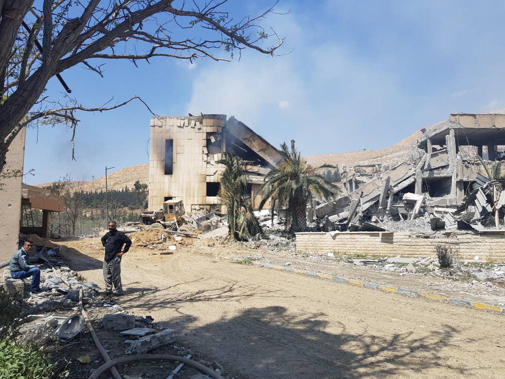 Former employees at the Barzah research site stand outside the ruined facility.