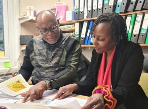 Chris Adegoke, Christian Voice International Development Manager, and Judy Green, secretary of Kenya Christian Voice, confer in the office.